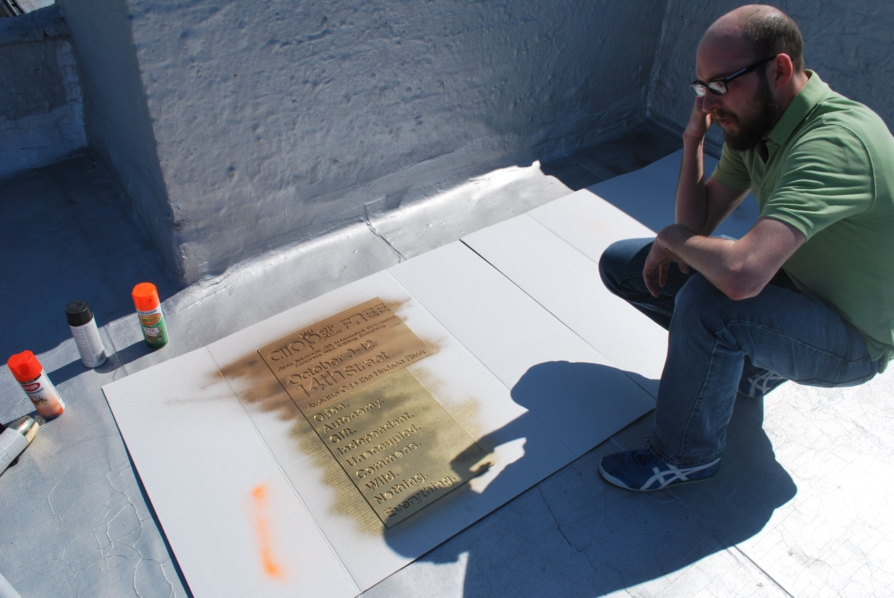 Carey looking at the painted stencil on the rooftop