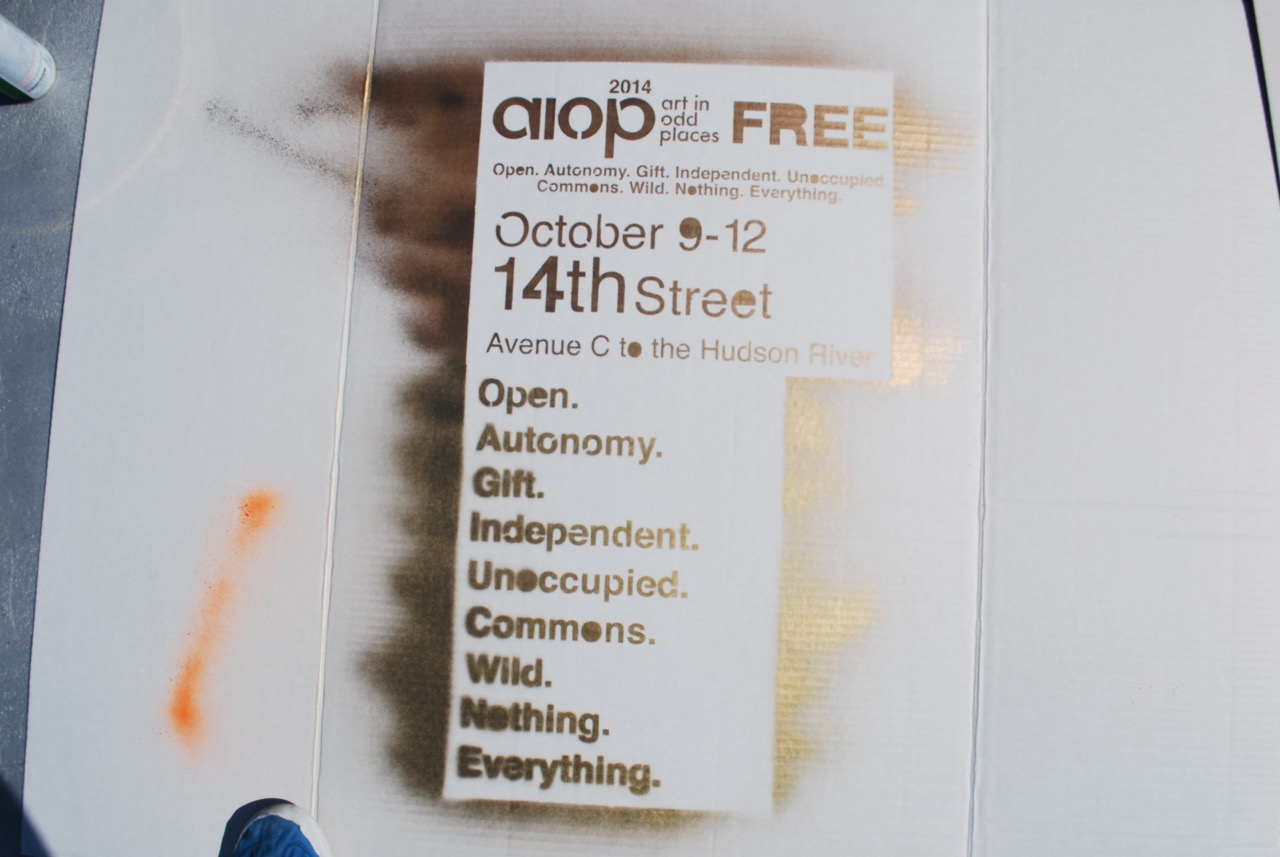 A spray painted stencil that says: AIOP FREE, October 9-12 on 14th Street Avenue C, with the tagline, Open, Autonomy, Gift, Independent, Unoccupied, Commons, Wild, Nothing, Everytihng.