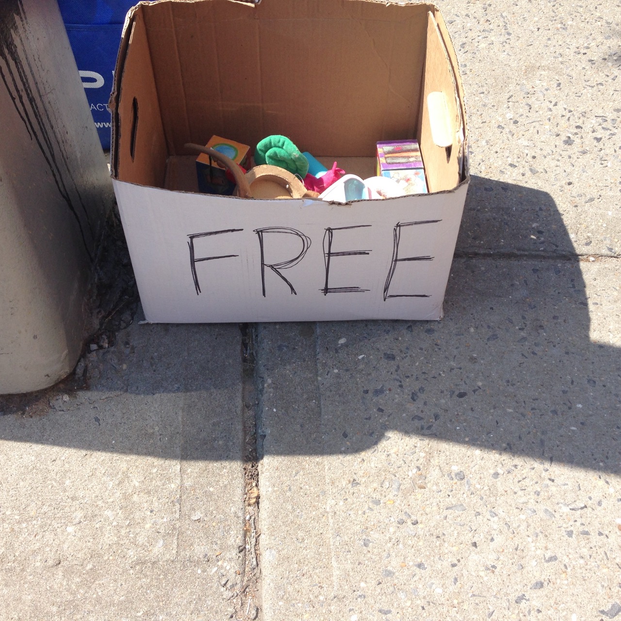 A box of items on the street curb with FREE written on the box